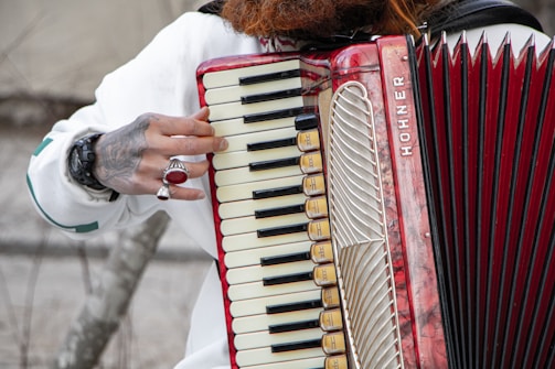 Musician playing a diatonic accordion adorned with a custom ar design sticker.