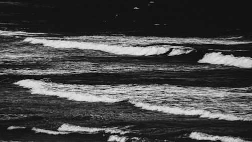 Abstract black and white image of waves crashing, emphasizing texture and contrast.
