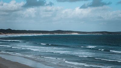 Wide shot of the beach club with the ocean waves gently rolling in the background.