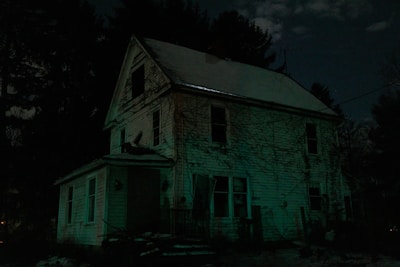 Horror book cover with a creepy abandoned house illuminated by a full moon.