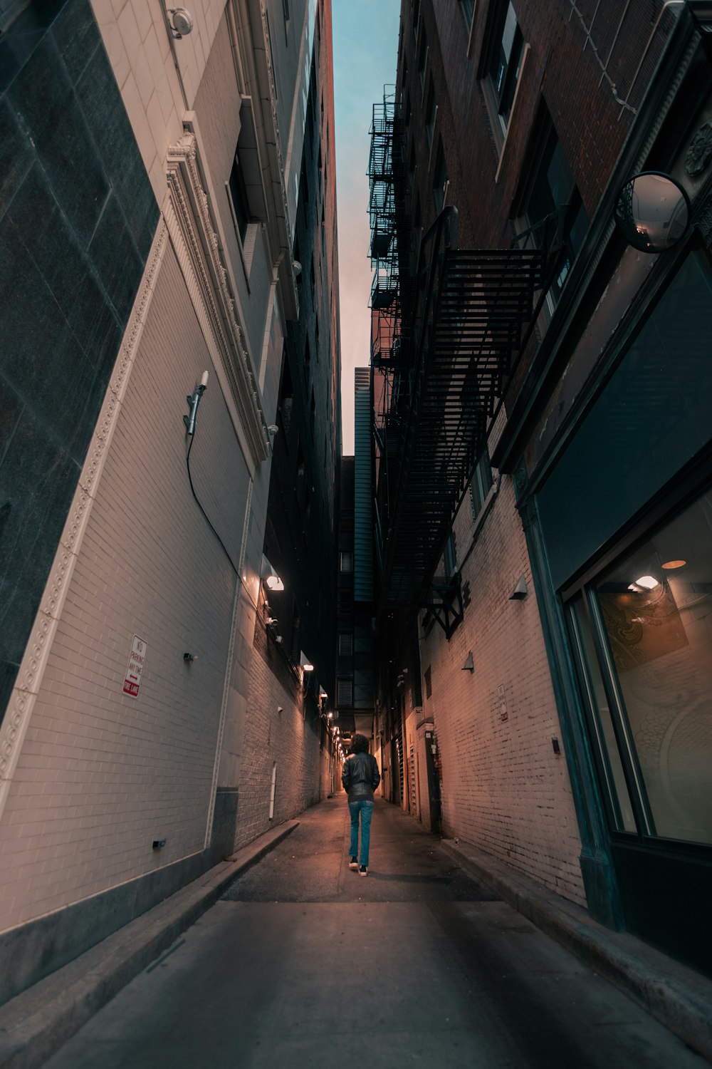 a person walking down a narrow alley way