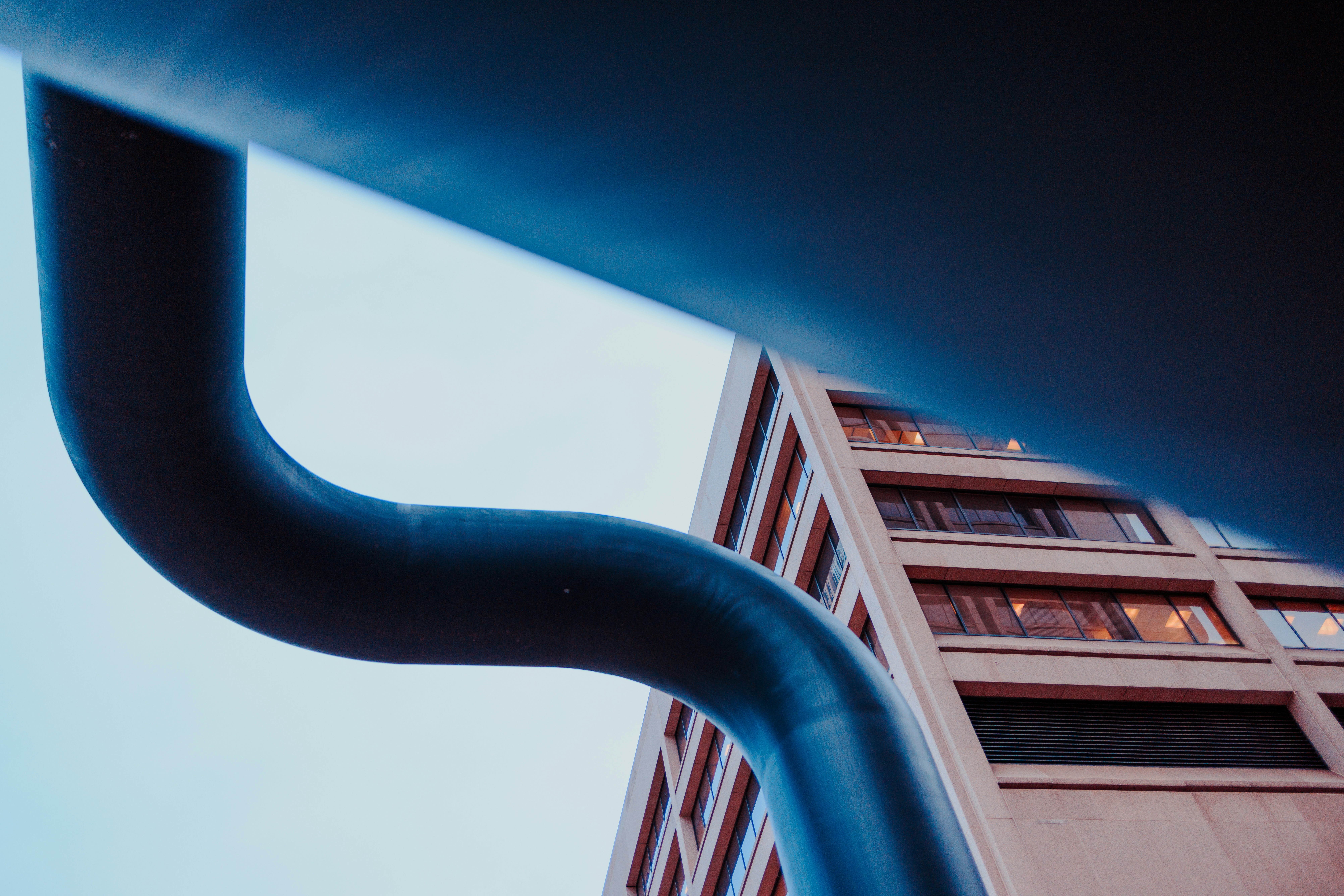 金属パイプを前にした高層ビル