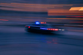 a police car driving down a street at night
