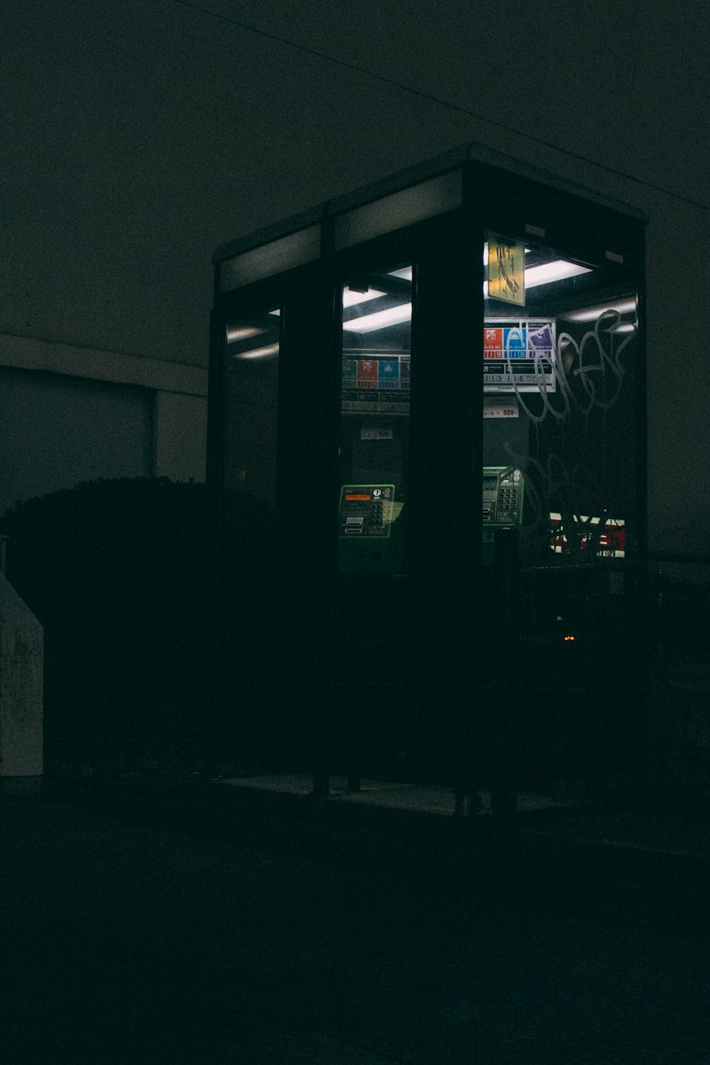 a bus stop sitting in the middle of a dark street
