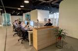 a group of people sitting at desks in an office
