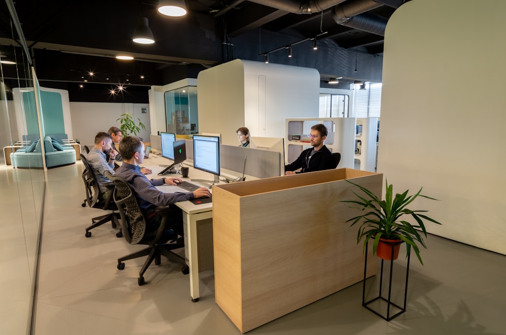 a group of people sitting at desks in an office