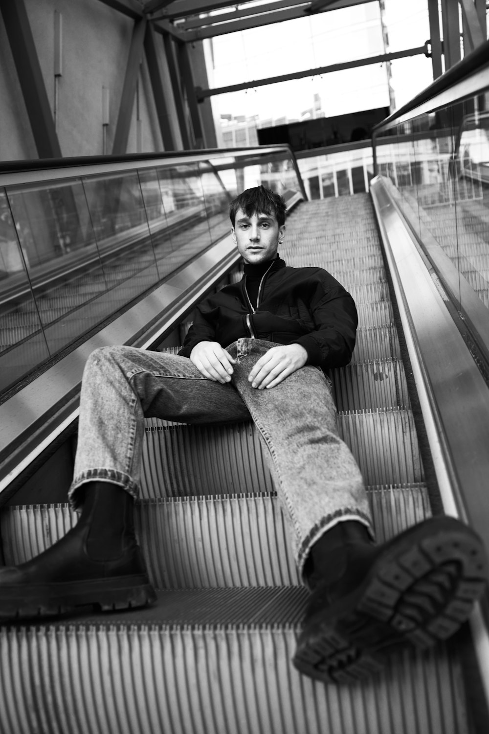 a man sitting on an escalator with his legs crossed