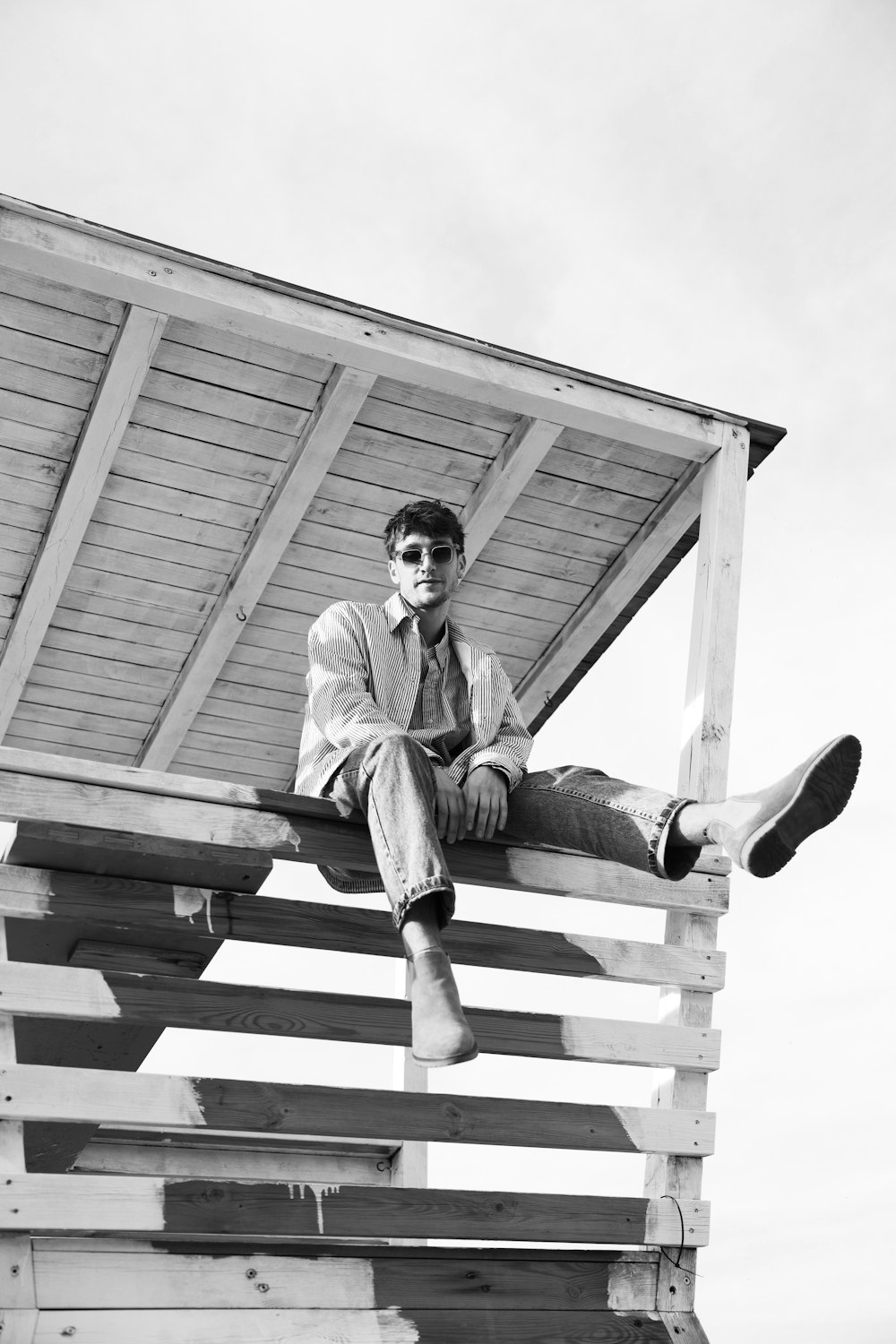 a man sitting on top of a wooden structure