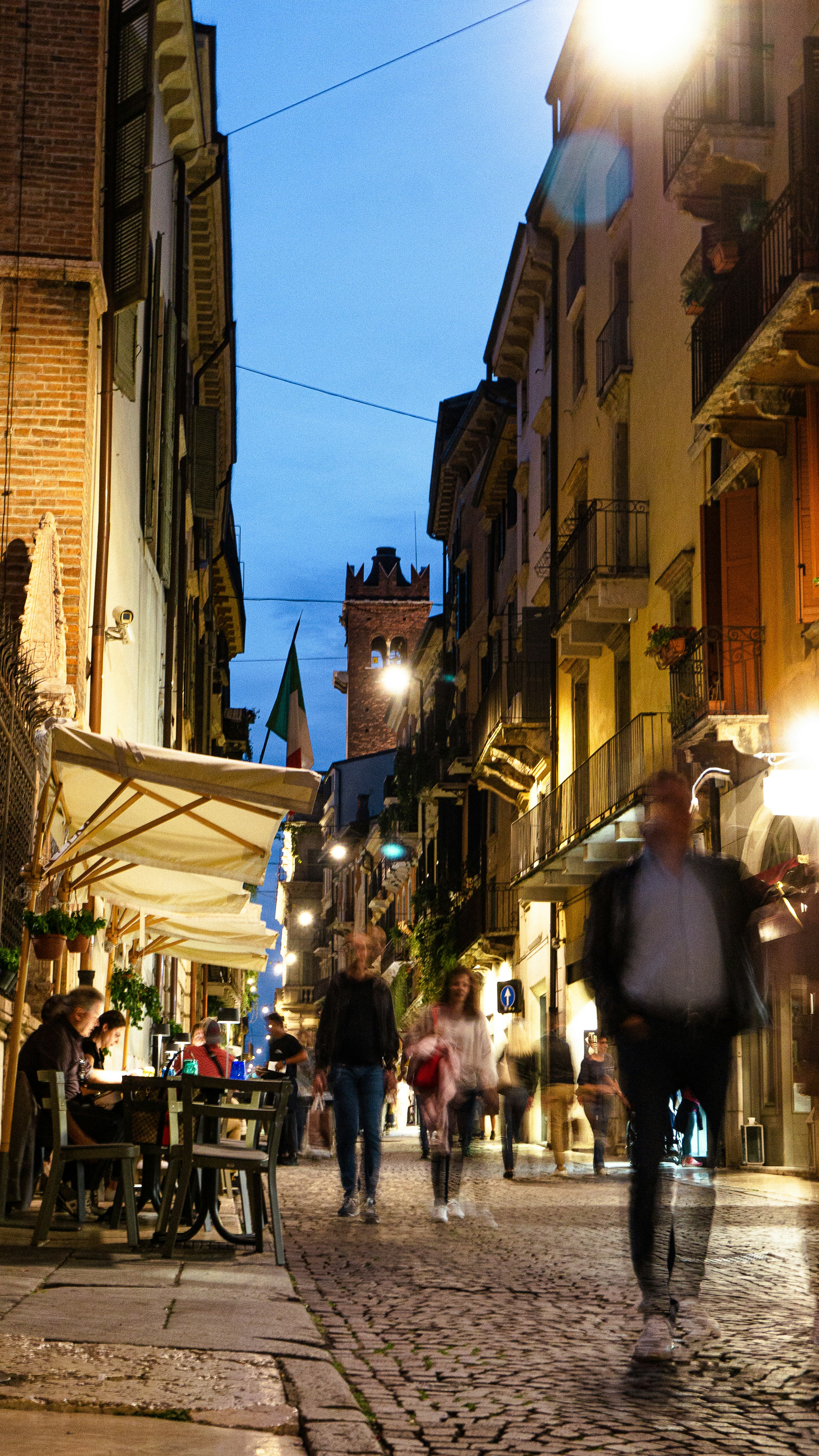 A sunlit cobblestone street in Rome lined with ancient buildings and vibrant cafes.