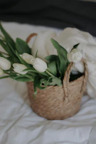 Colorful mix of tulips and daisies arranged in a woven basket, perfect for home decoration.