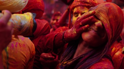 Crowd of happy participants celebrating together with colorful powder in the air.