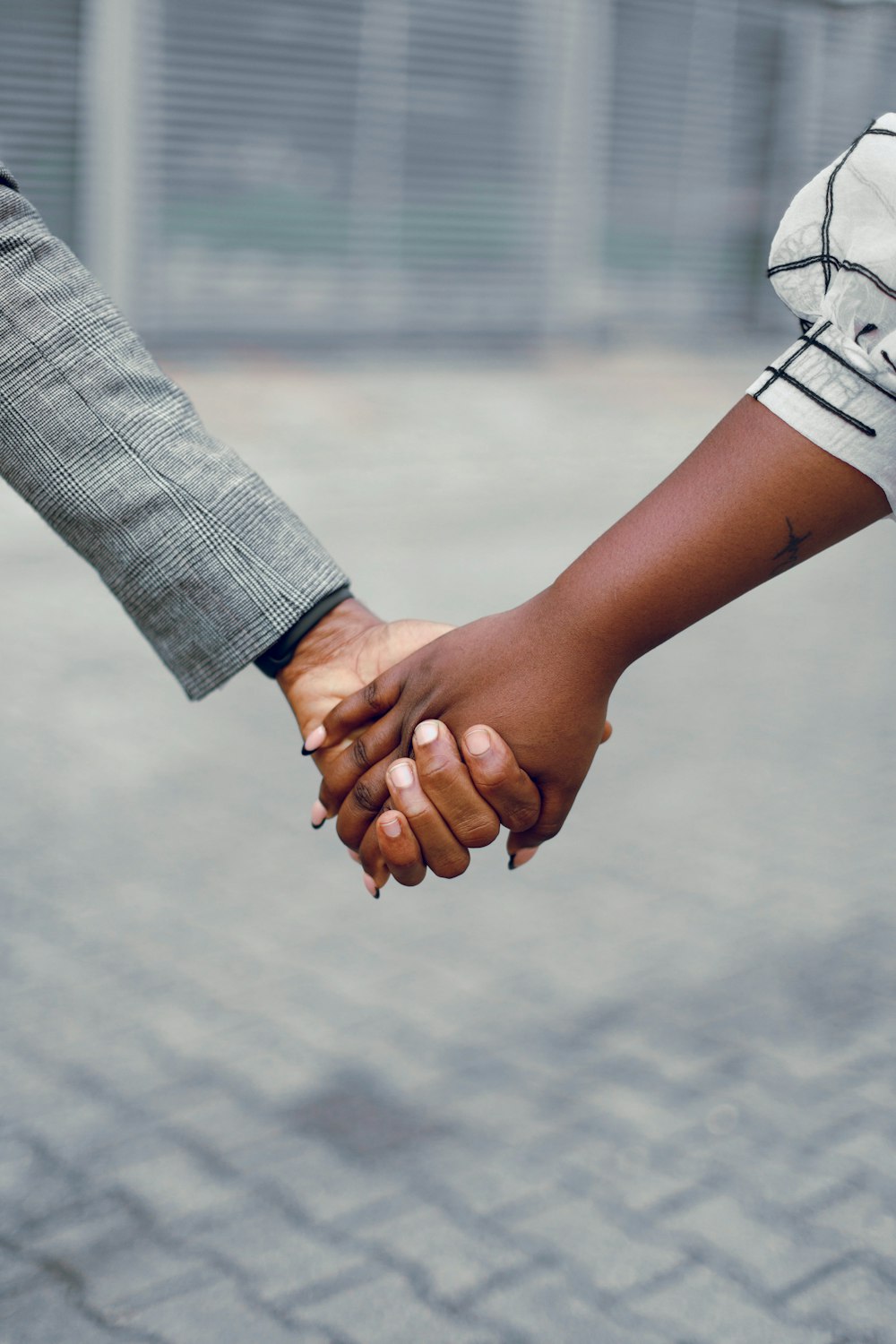 a close up of two people holding hands