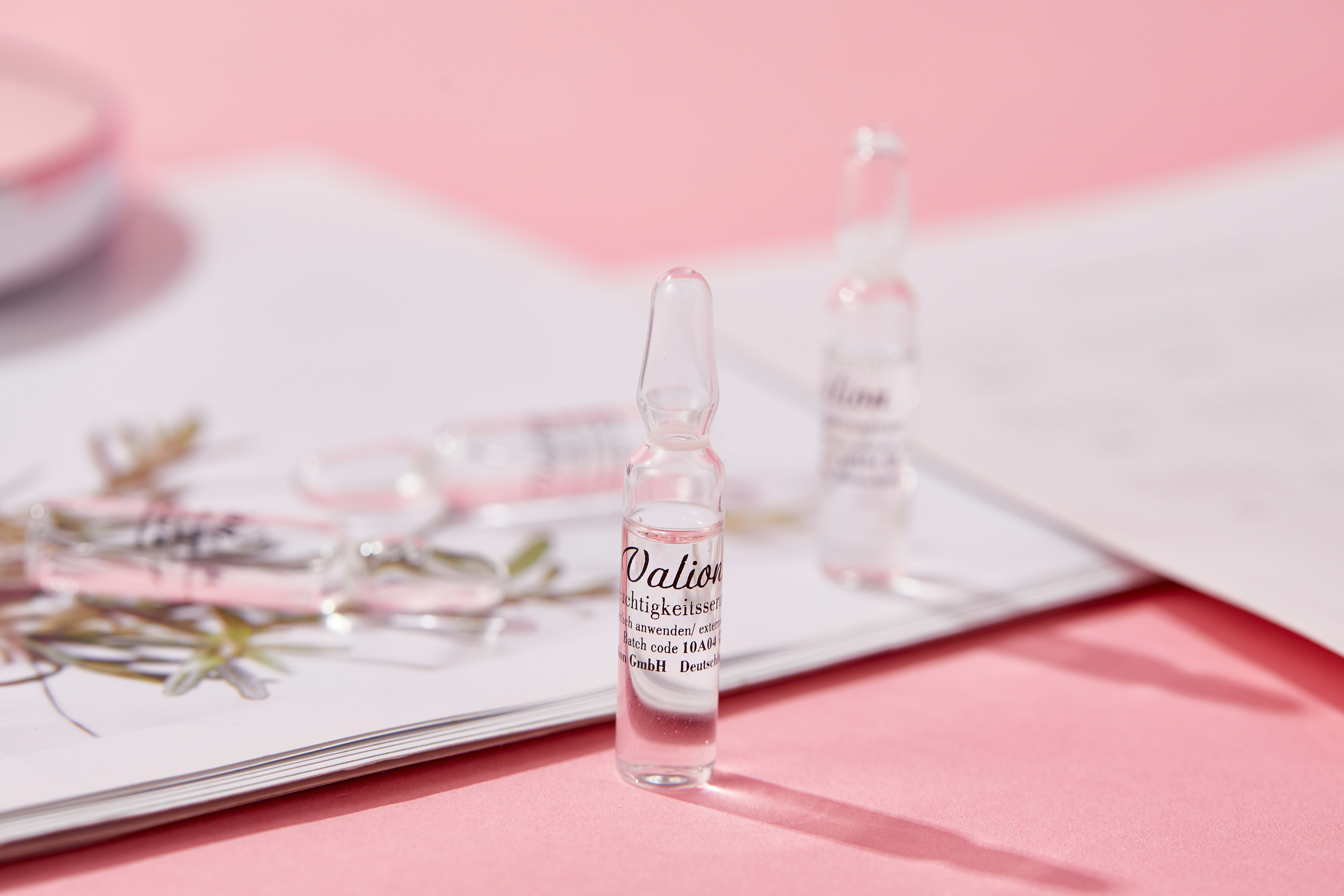 a pink table topped with a bottle of liquid