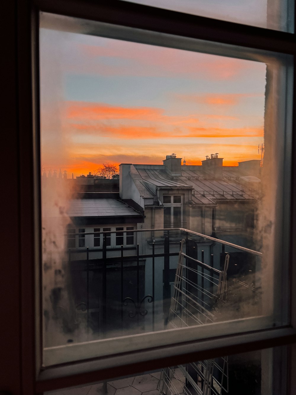a window with a view of a city at sunset