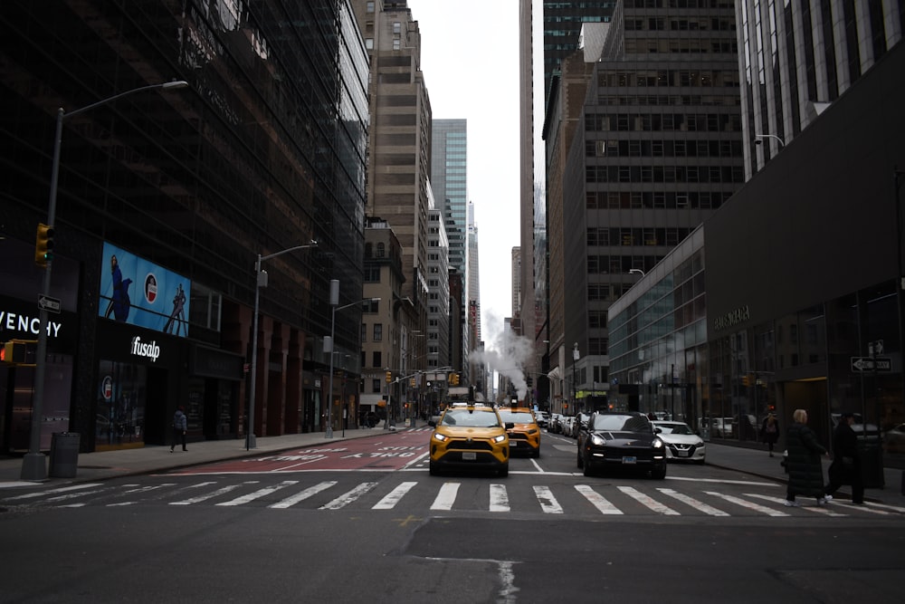 a city street filled with traffic next to tall buildings