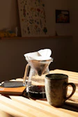 A warm, inviting pour-over setup with steam rising in a cozy kitchen corner.
