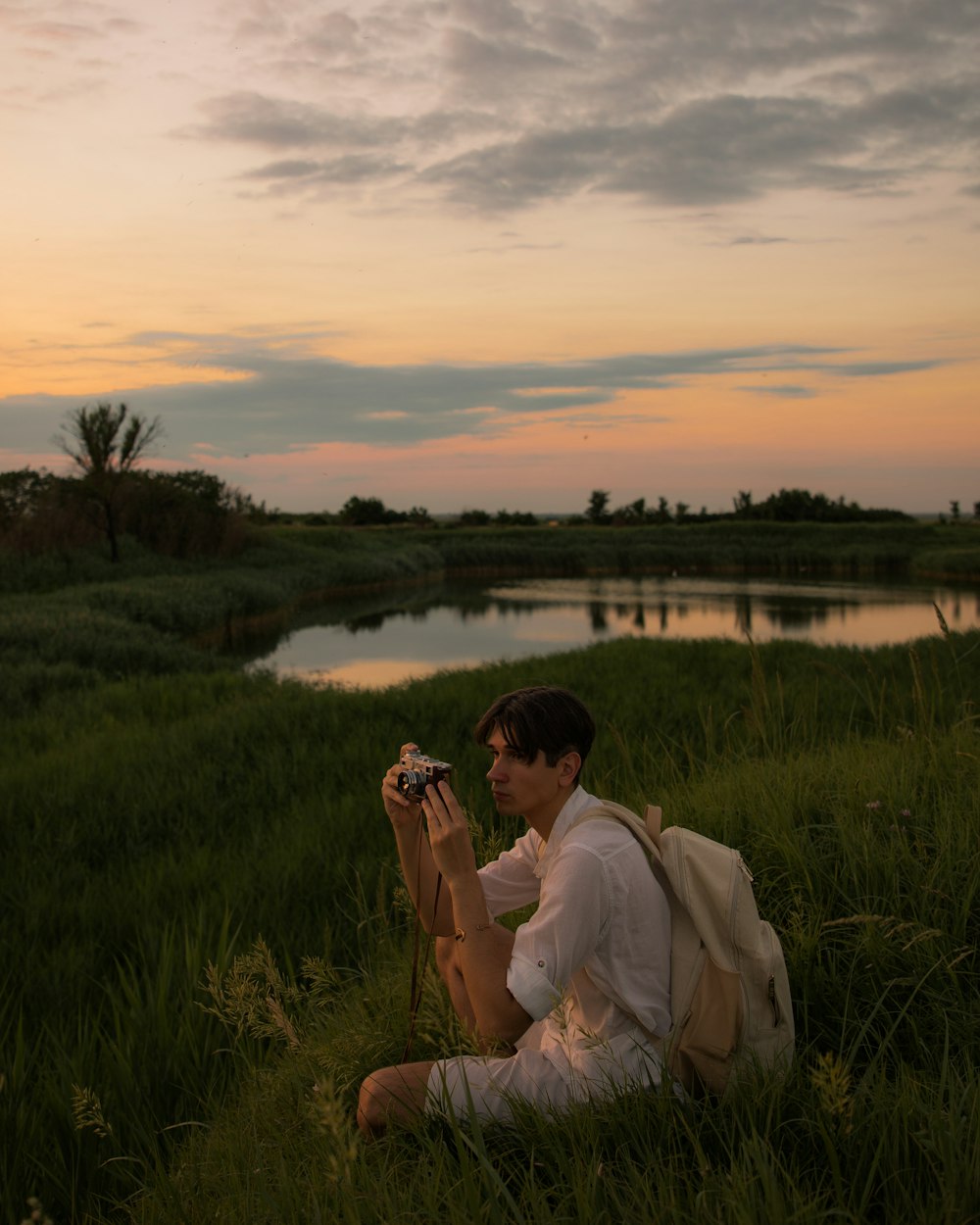 uma pessoa sentada em um campo com uma câmera