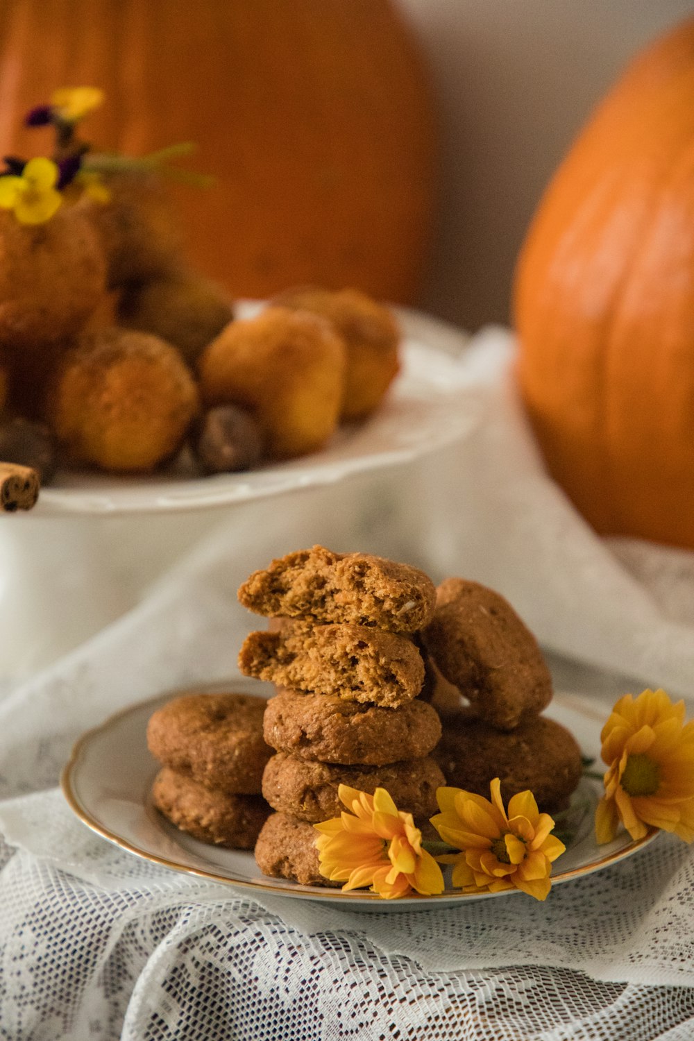 a plate of cookies on a table with pumpkins in the background