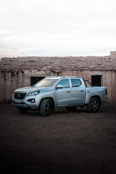 a silver truck parked in front of a building