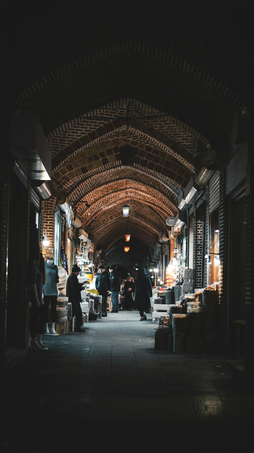 a group of people walking down a dark alley way