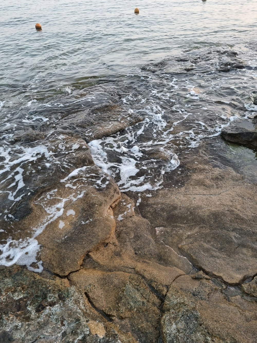 a view of a body of water with rocks in the foreground