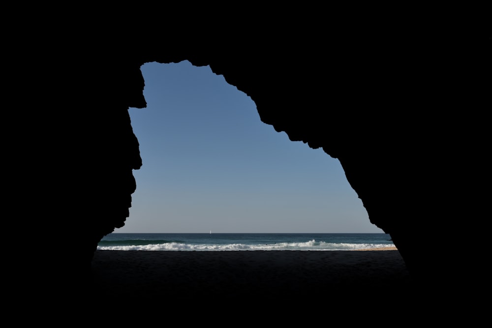 a view of the ocean through a cave