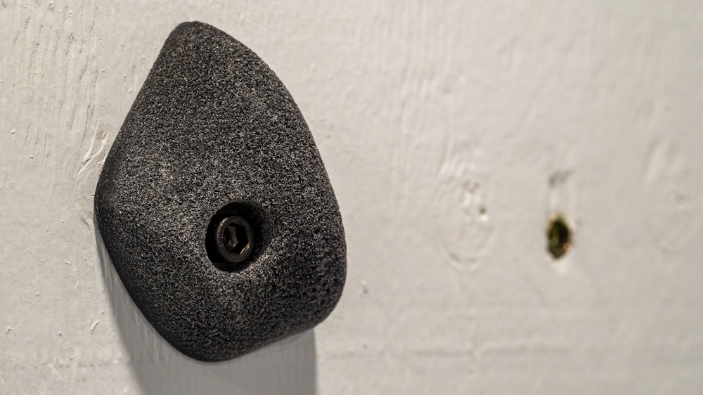 a rock mounted to a wall with a hole in it