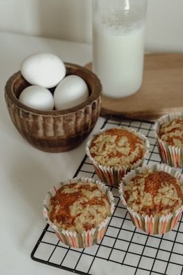 Freshly baked whole grain muffins with nuts on a wooden board.