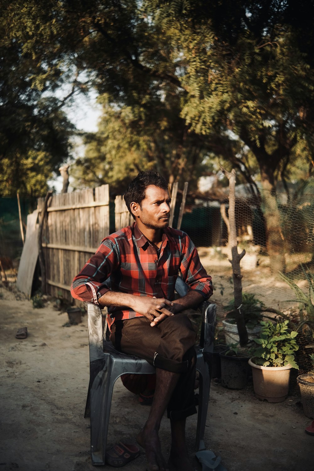 Un homme assis sur une chaise dans une cour