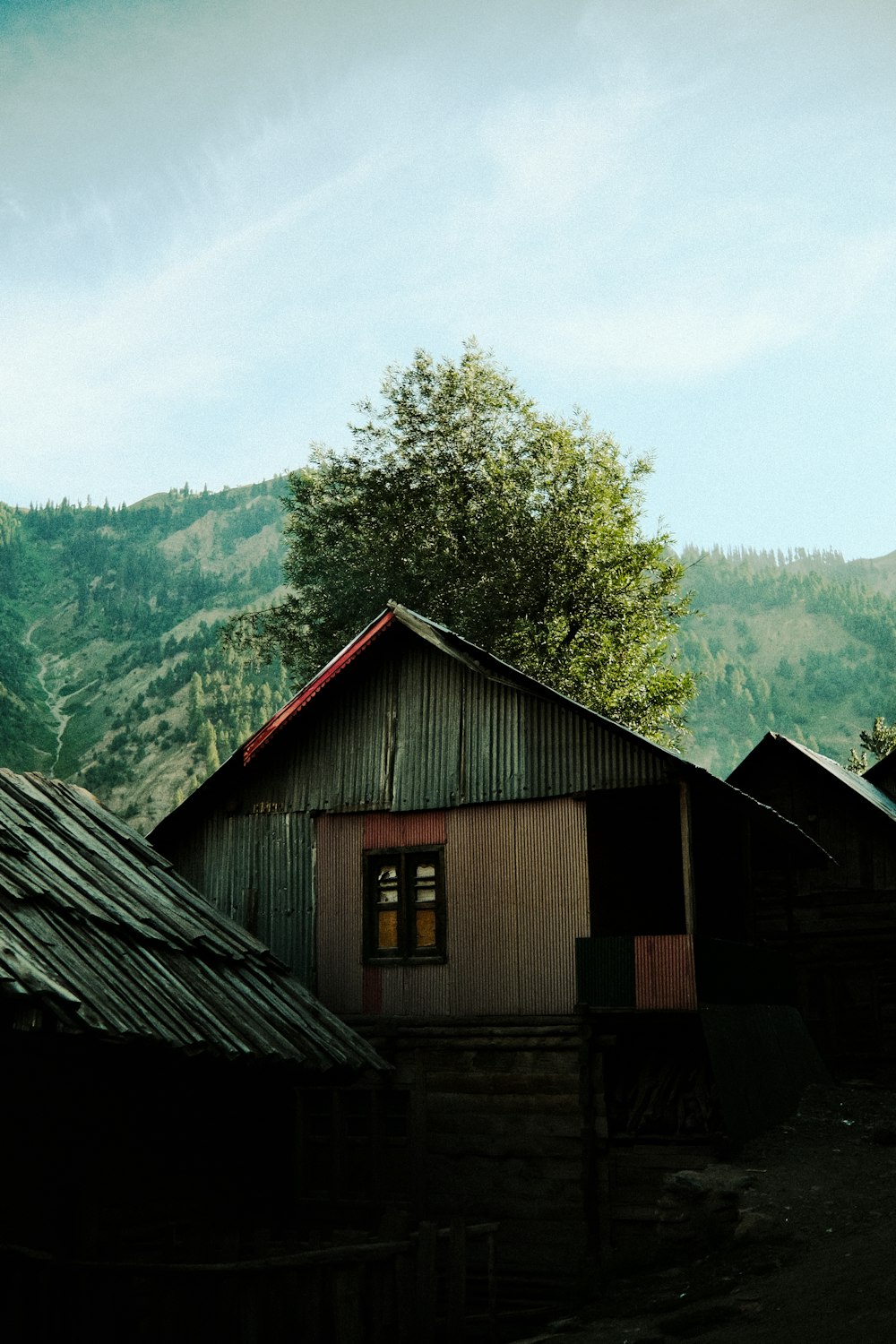 a group of wooden buildings with mountains in the background