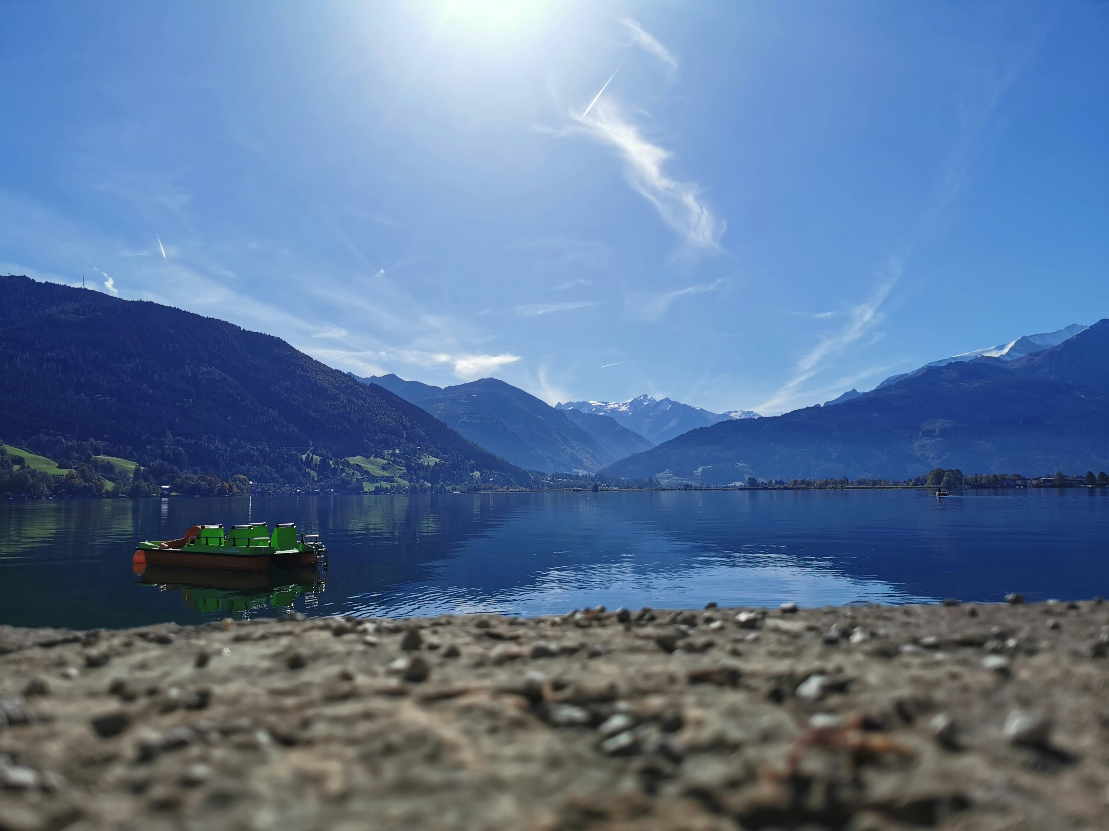 Ein kleines Boot, das auf einem See schwimmt, umgeben von Bergen
