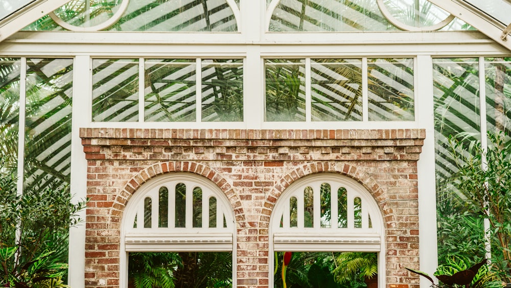 a brick building with arched windows in a garden