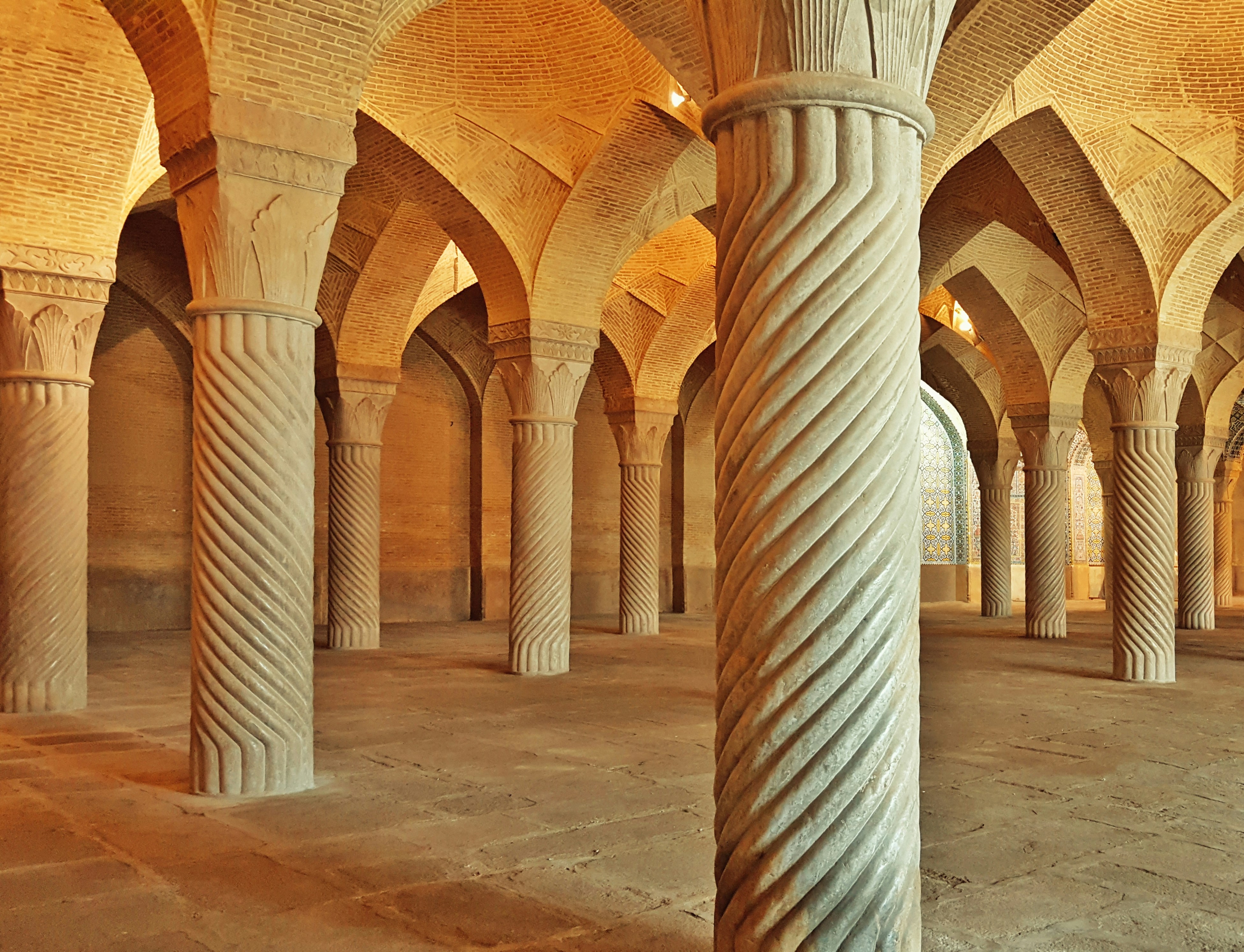 a large room with columns and a clock on the wall