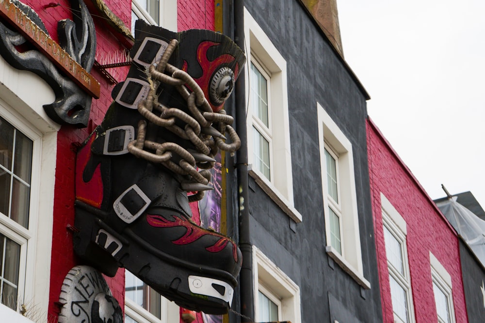 a pair of black and red shoes hanging from the side of a building