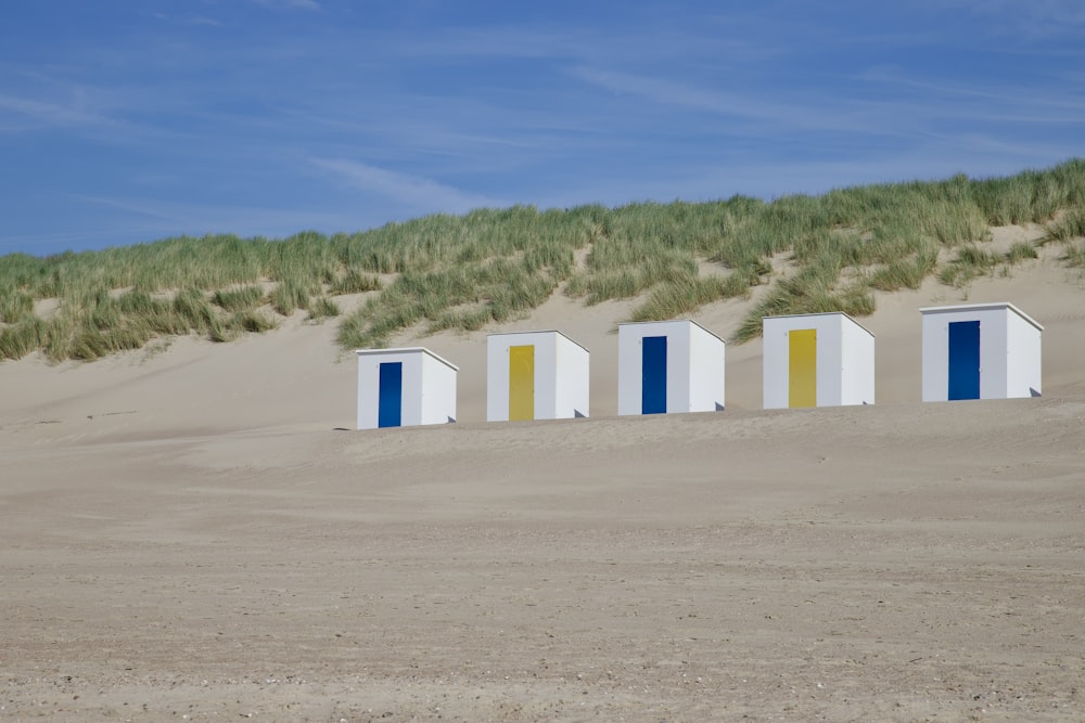 a row of beach huts sitting on top of a sandy beach