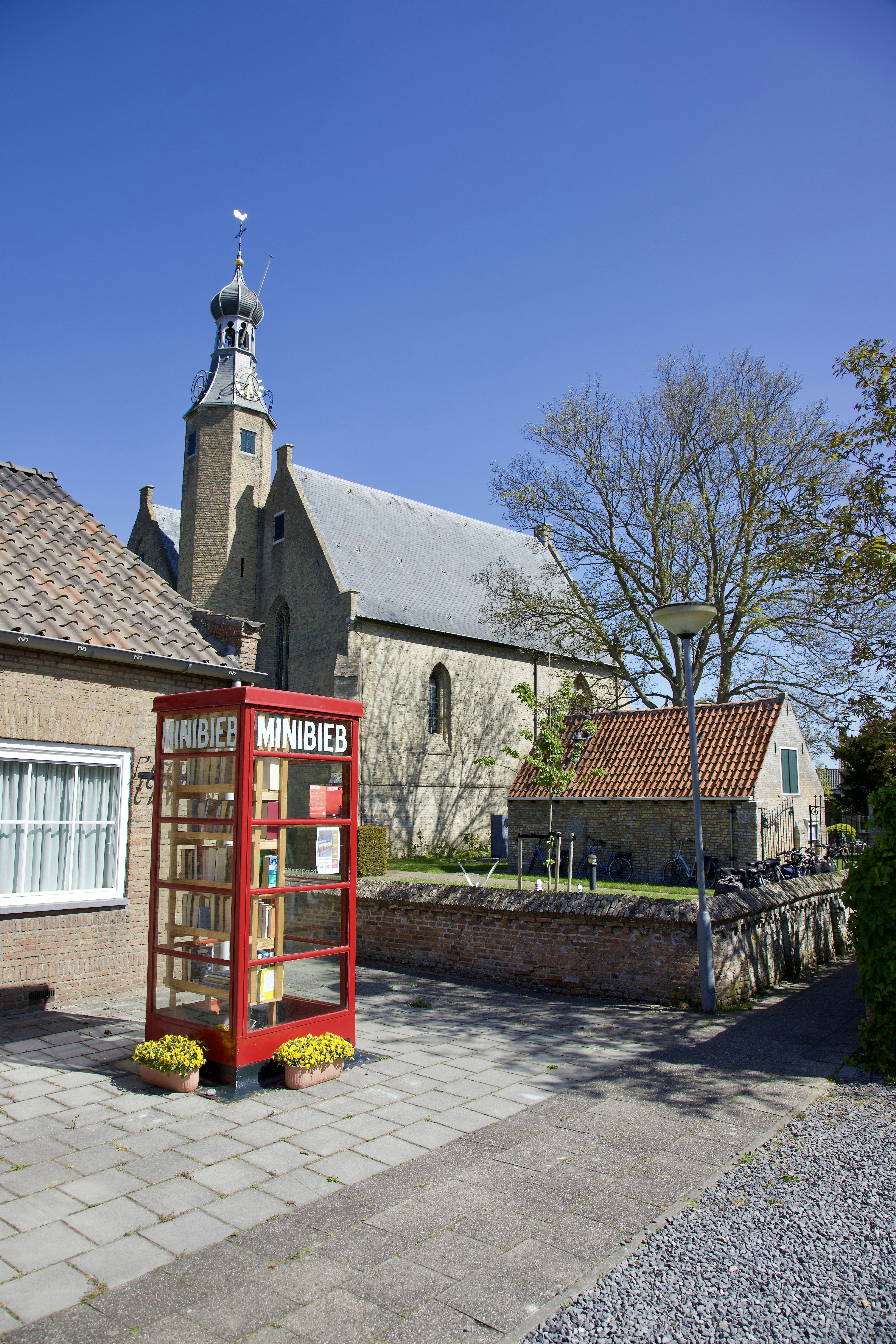 a red phone booth sitting on the side of a road