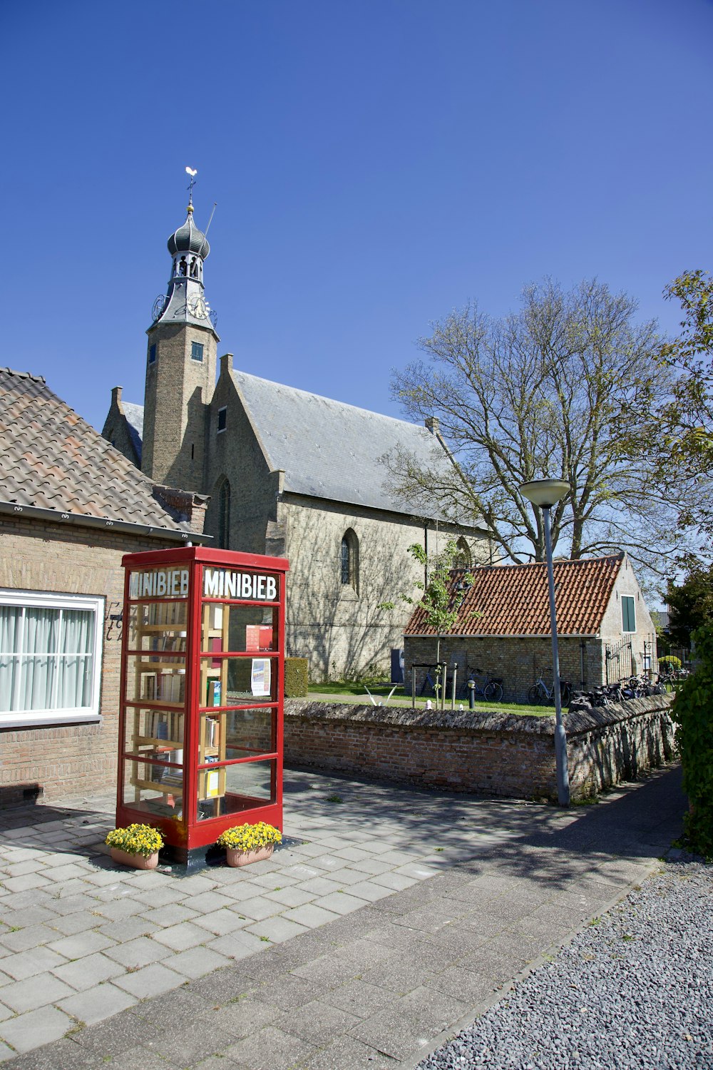 a red phone booth sitting on the side of a road