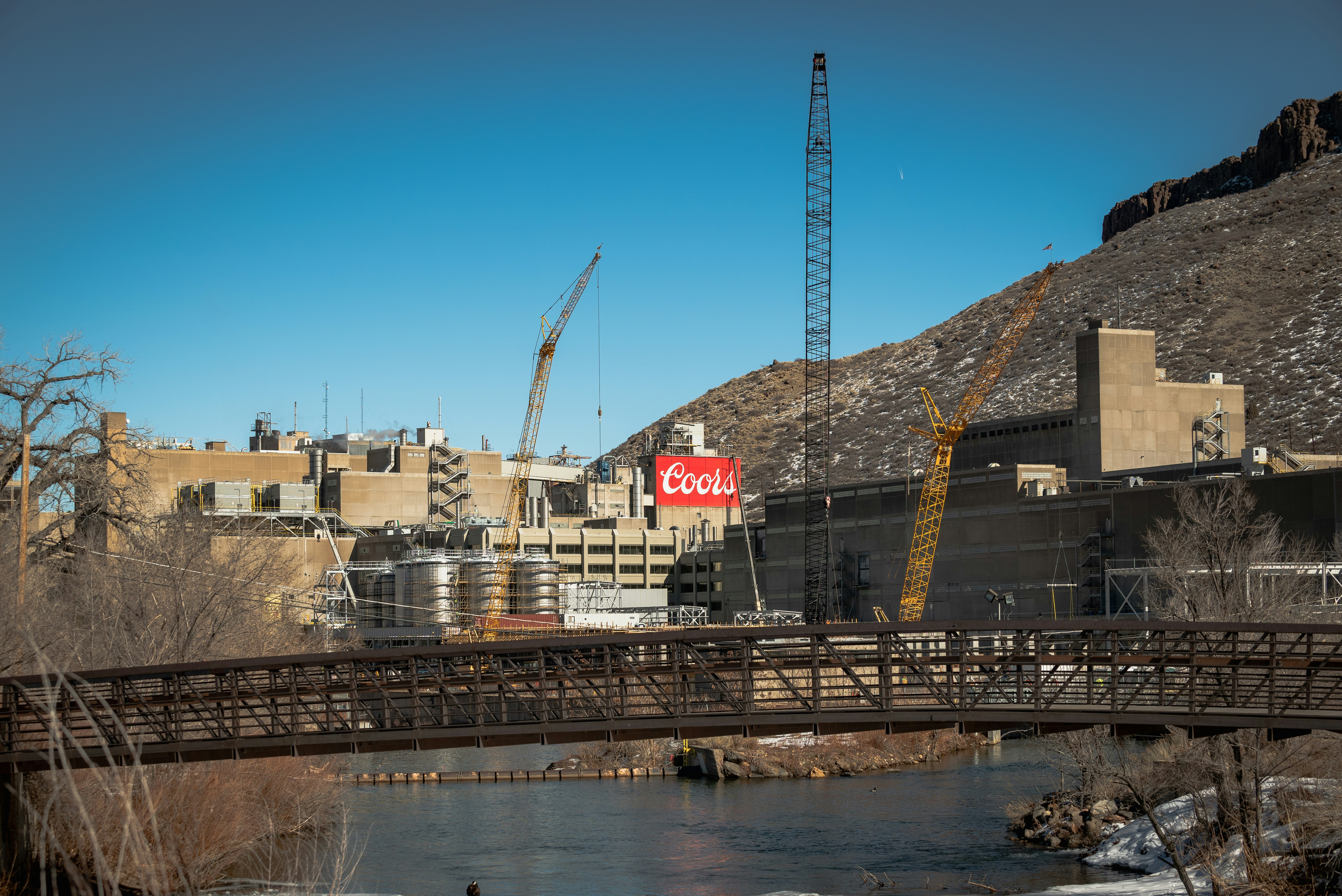 a bridge over a body of water with a crane in the background