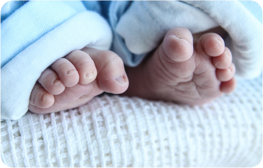 a close up of a baby's feet on a blanket