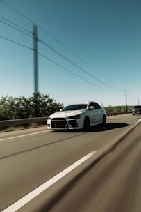 A sports car in motion on a highway.