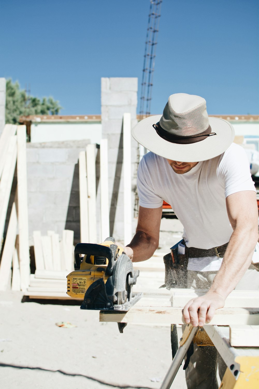 a man in a hat working on a piece of wood