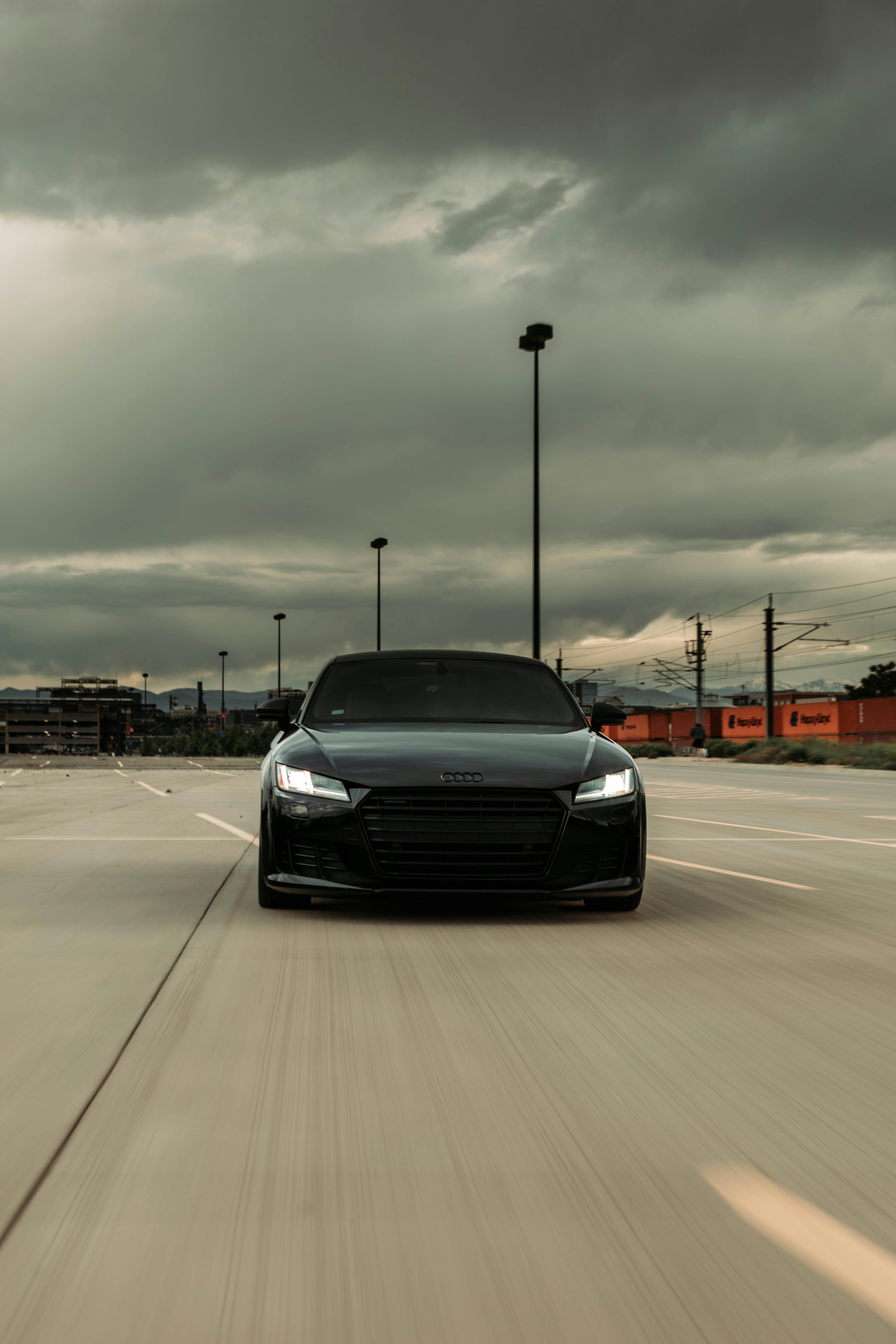 Audi RS model on empty mountain road at dusk, long exposure light trails, dramatic sky gradient from deep blue to orange, dark moody atmosphere