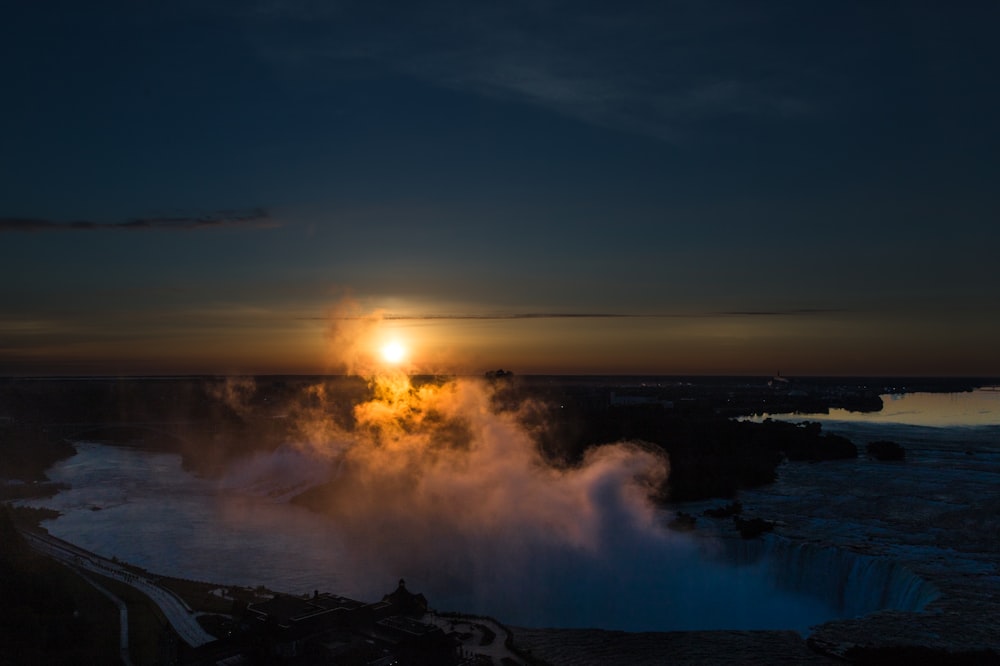 the sun is setting over a body of water