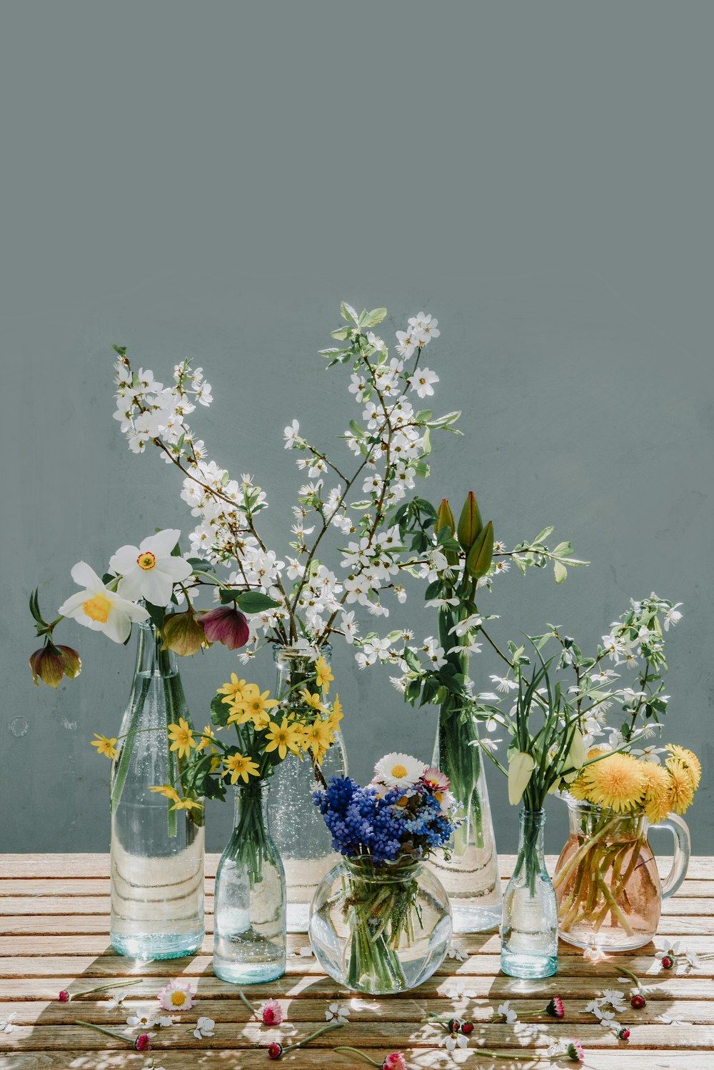 Eine Gruppe von Vasen gefüllt mit Blumen auf einem Holztisch