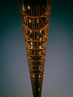Night view of a steel bridge illuminated, demonstrating structural elegance