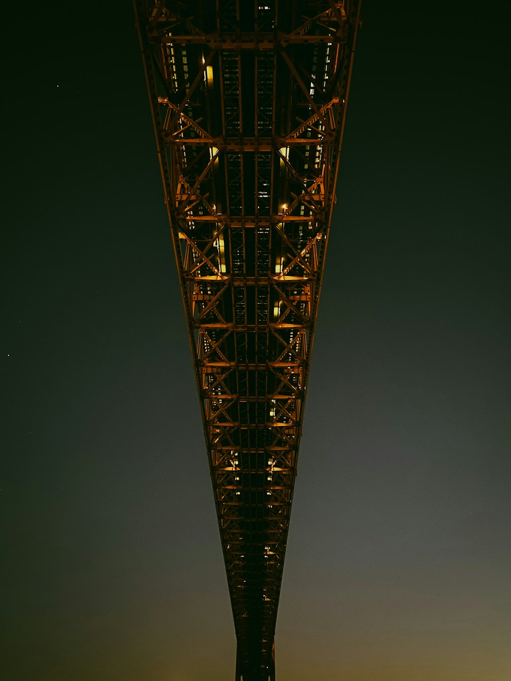 uma ponte muito alta que é iluminada à noite