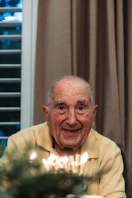 A veteran smiling warmly while receiving support at home.