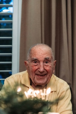 Santiago smiling warmly while sitting in his adapted living room, sunlight filtering through the window