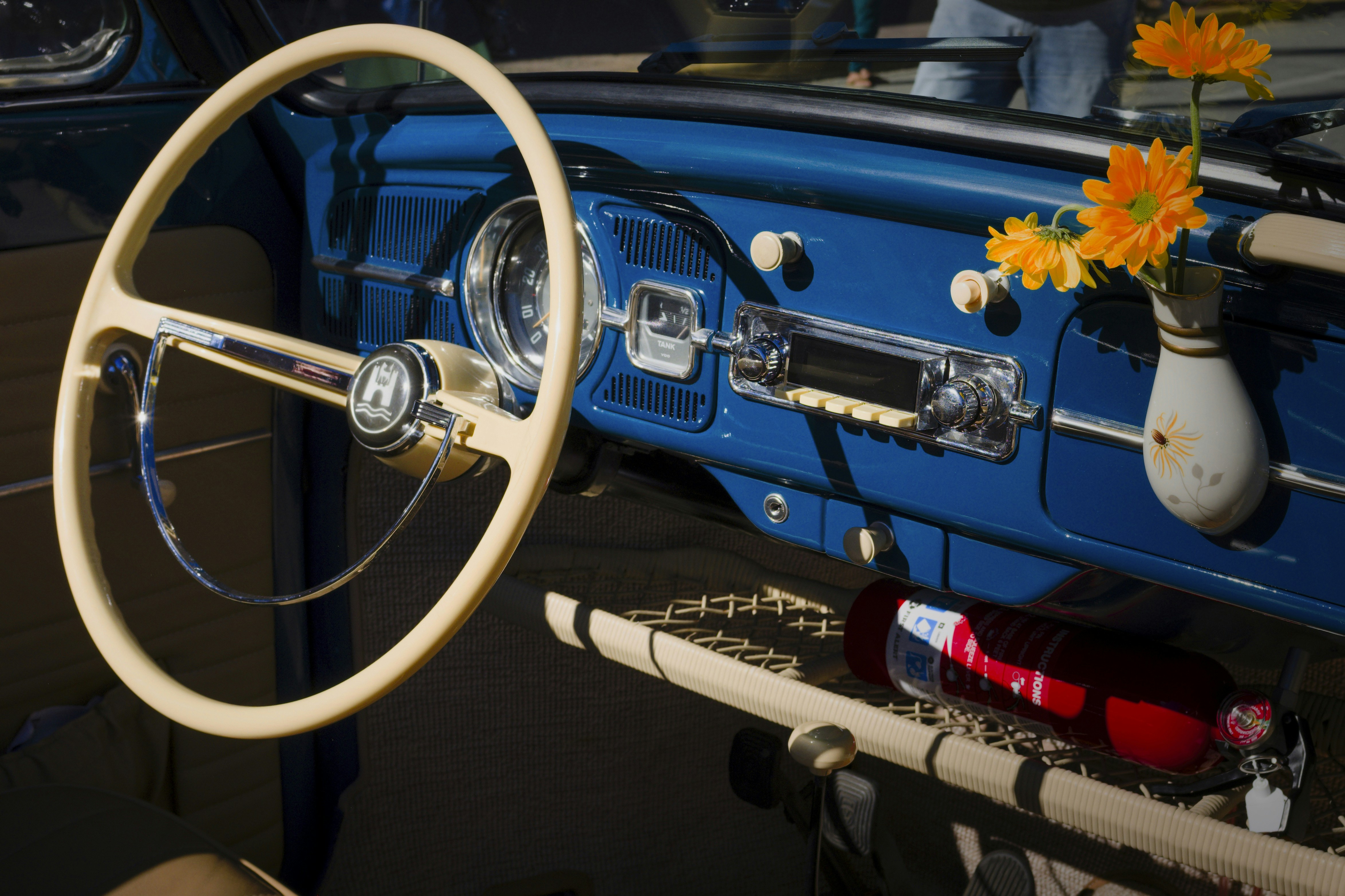 a blue car with a steering wheel and a vase of flowers