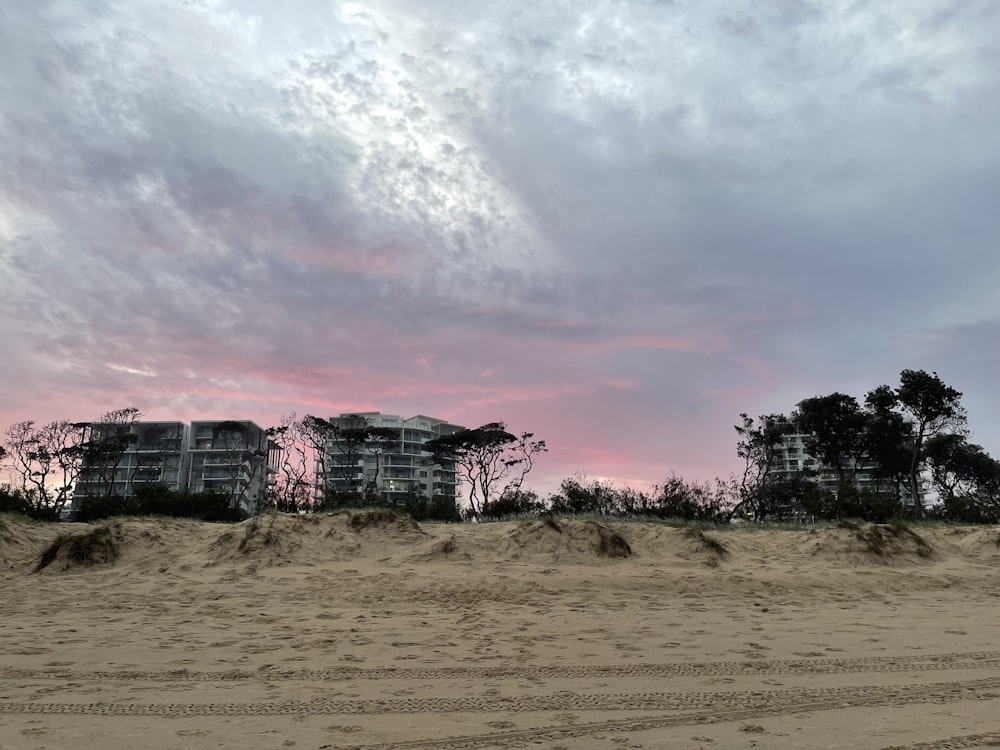 a sandy beach with a building in the distance